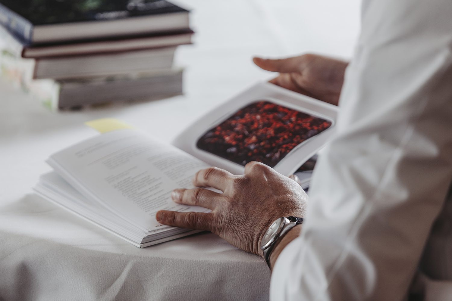 detailfoto van hand van chef-kok met boek met recepten